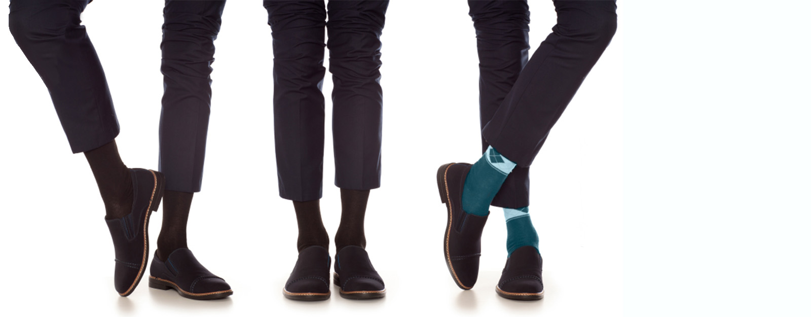 Image of three pairs of legs in matching business slacks and shoes. One set of legs has turquois colored socks.